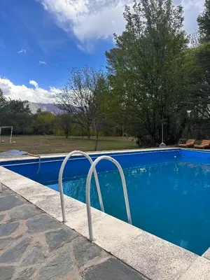 a blue swimming pool with a metal railing next to it at Tunquelen in Las Calles