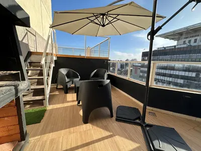 a balcony with a table and chairs and an umbrella at Departamento c/ piscina climatizada privada, 4 habitaciones en el centro de Cordoba in Cordoba