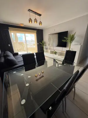 a living room with a glass table and chairs at Departamento c/ piscina climatizada privada, 4 habitaciones en el centro de Cordoba in Cordoba