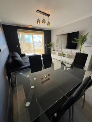 a living room with a glass table and chairs at Departamento c/ piscina climatizada privada, 4 habitaciones en el centro de Cordoba in Cordoba