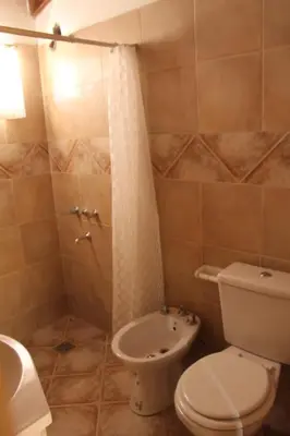 a bathroom with a toilet and a shower and a sink at Cabaña Las Marias 4 in Cordoba