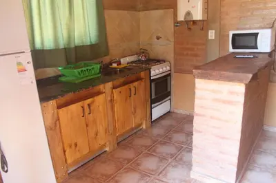 a small kitchen with a stove and a microwave at Cabaña Las Marias 4 in Cordoba
