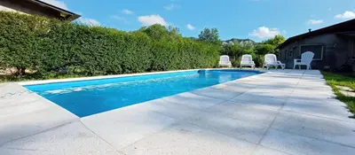a swimming pool with chairs next to a house at Schönes Loft in Villa General Belgrano
