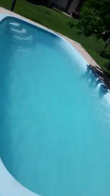 a swimming pool with blue water in a yard at Cabañas Nicasio in Merlo