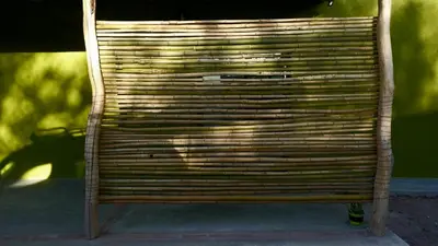 a wooden bench is sitting on a sidewalk at las tacanas casa del alto in Nono