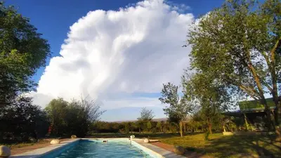 a large swimming pool in a park with a cloudy sky at las tacanas casa del alto in Nono
