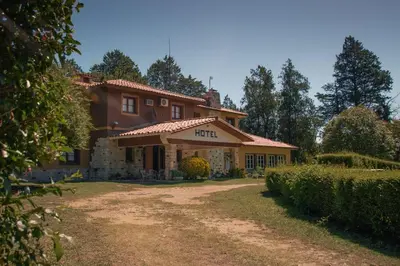 a house with a dirt road in front of it at Hotel Lago Los Molinos in Villa Ciudad de America