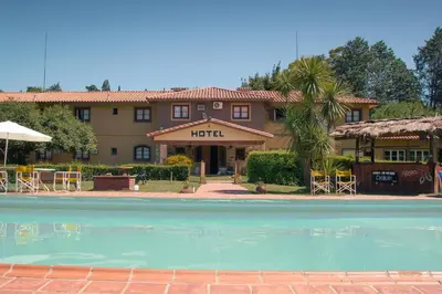 a hotel with a swimming pool in front of a building at Hotel Lago Los Molinos in Villa Ciudad de America
