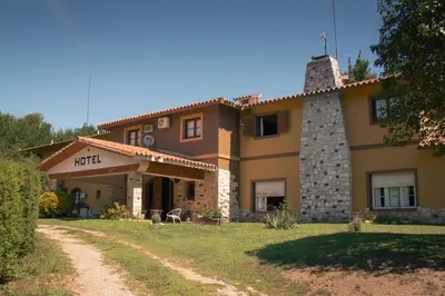 a large yellow house with a chimney on a yard at Hotel Lago Los Molinos in Villa Ciudad de America