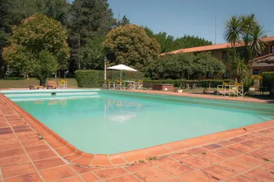 a large blue swimming pool with a red brick at Hotel Lago Los Molinos in Villa Ciudad de America