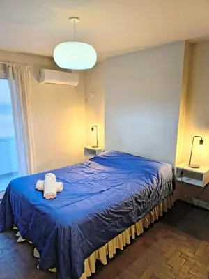 a bedroom with a blue bed with a towel on it at HERMOSO - CATEGORIA Departamento 90 m2 CENTRO con COCHERA opcional in Cordoba