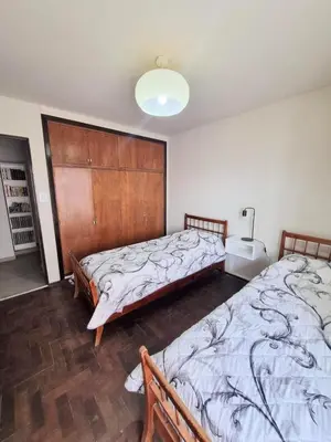 a bedroom with two beds and a wooden headboard at HERMOSO - CATEGORIA Departamento 90 m2 CENTRO con COCHERA opcional in Cordoba