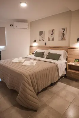 a bedroom with a large bed with two towels on it at Hotel Libertad in Villa Carlos Paz