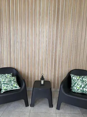 two black chairs and a table with a clock on it at Hotel Libertad in Villa Carlos Paz