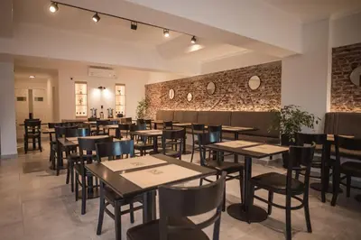 a restaurant with tables and chairs and a brick wall at Hotel Libertad in Villa Carlos Paz