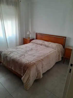 a bedroom with a bed and two nightstands and a bed sidx sidx sidx at Departamento Carlos Paz in Villa Carlos Paz