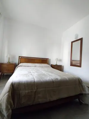 a bedroom with a large bed and a mirror at Departamento Carlos Paz in Villa Carlos Paz
