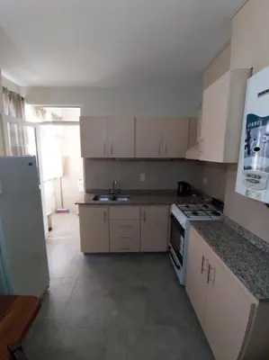 a kitchen with white cabinets and a stove top oven at Departamento Carlos Paz in Villa Carlos Paz