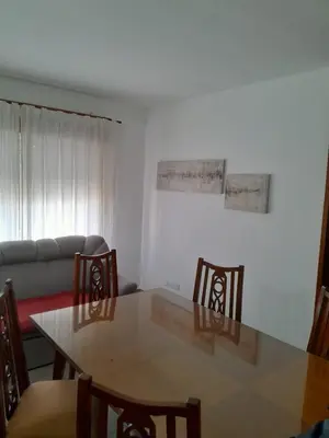 a dining room with a table and chairs and a couch at Departamento Carlos Paz in Villa Carlos Paz