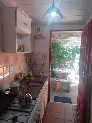a kitchen with a sink and a stove and a table at Alojamiento x dia Cactus Serrano in Merlo