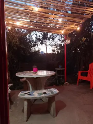 a picnic table under a pergola with a pink cup on it at Alojamiento x dia Cactus Serrano in Merlo