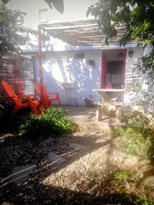 a patio with two red chairs and a table at Alojamiento x dia Cactus Serrano in Merlo