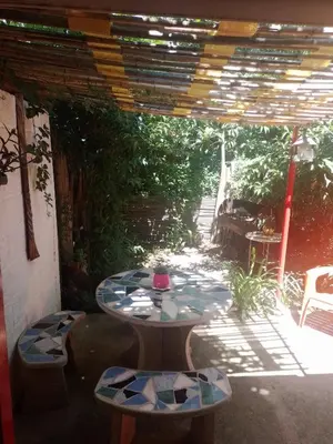 a patio with two tables and a table and chairs at Alojamiento x dia Cactus Serrano in Merlo