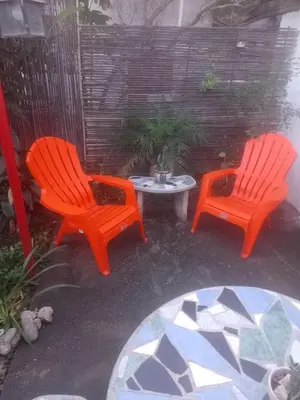 two orange chairs and a table on a patio at Alojamiento x dia Cactus Serrano in Merlo