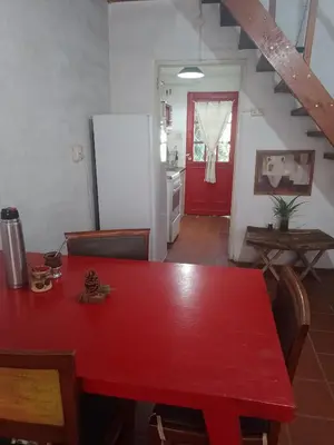 a red table in a kitchen with a red refrigerator at Alojamiento x dia Cactus Serrano in Merlo