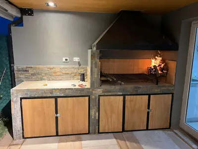 a kitchen with a fireplace in the corner of a room at Reserva Tajamar in Alta Gracia