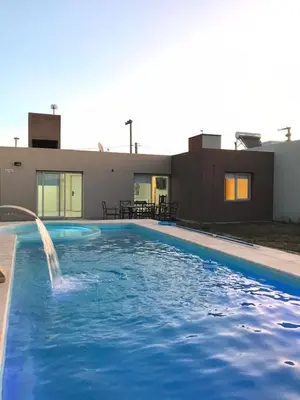 a swimming pool with a fountain in front of a building at Reserva Tajamar in Alta Gracia