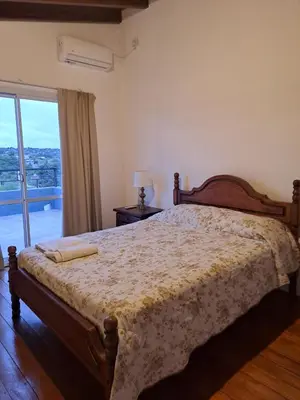 a bedroom with a large bed and a window at La Casita Estanciera in Estancia Vieja