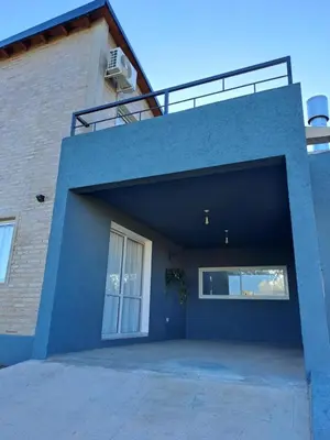 a blue building with a large garage with a window at La Casita Estanciera in Estancia Vieja