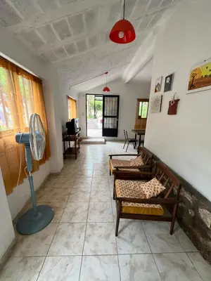 a living room with two couches and a fan at Casa de verano Marcos Lopez in Villa Cura Brochero