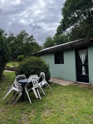 two chairs and a table in front of a house at Casa de verano Marcos Lopez in Villa Cura Brochero
