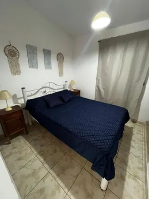 a bedroom with a bed with a blue comforter at Casa de verano Marcos Lopez in Villa Cura Brochero