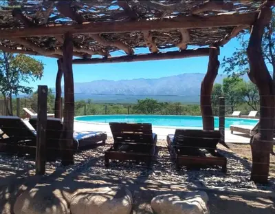 a group of chairs sitting under a pavilion next to a pool at CASA DE CAMPO COLIBRI EN LA MATILDE in San Javier