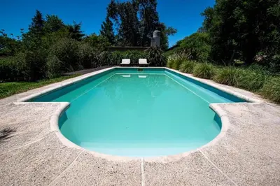 a swimming pool with blue water in a backyard at Casa en Sierras de Córdoba, Villa la Bolsa. in La Bolsa