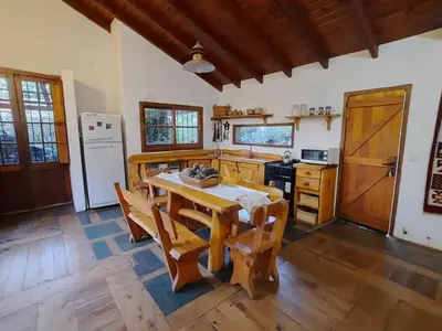 a kitchen with a table and chairs in a room at Casa en Sierras de Córdoba, Villa la Bolsa. in La Bolsa