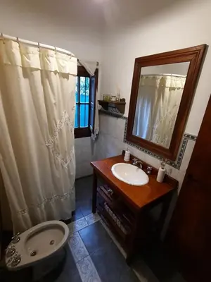 a bathroom with a sink and a mirror and a toilet at Casa en Sierras de Córdoba, Villa la Bolsa. in La Bolsa