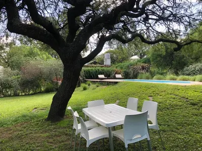 a white table and chairs under a tree at Casa en Sierras de Córdoba, Villa la Bolsa. in La Bolsa