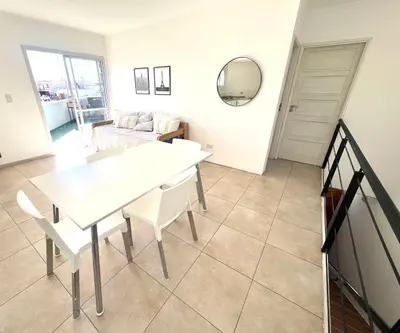 a dining room with a white table and chairs at Depto Siria in Almafuerte