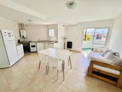 a kitchen and living room with a table and a couch at Depto Siria in Almafuerte