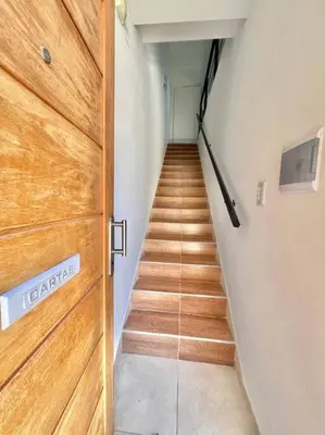 a hallway with a wooden door and a staircase at Depto Siria in Almafuerte