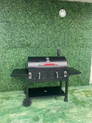 a black grill sitting in front of a green wall at Depto Siria in Almafuerte