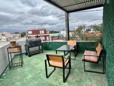 a patio with tables and chairs on a roof at Depto Siria in Almafuerte