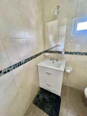 a white bathroom with a sink and a mirror at Depto Siria in Almafuerte