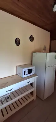 a kitchen with a microwave and a refrigerator at Cabaña Rincón de Afrodita in San Lorenzo