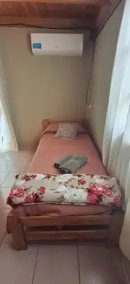 a small bedroom with a bed with flowers on it at Cabaña Rincón de Afrodita in San Lorenzo