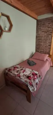a small bed in a room with avertisement at Cabaña Rincón de Afrodita in San Lorenzo